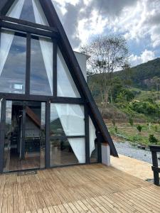 a house with large glass doors on a wooden deck at Chalé do Campo in Sumidouro