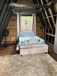 a bed in a room with a window at Chalé do Campo in Sumidouro