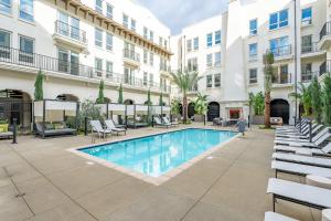 a pool in the courtyard of a building with white buildings at The Village Collection with Gym Pool and Spa in Montclair