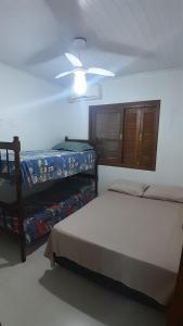 een slaapkamer met twee bedden en een plafondventilator bij Casa Ana y Ángelo in Pântano Grande