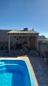 een blauw zwembad voor een huis bij Casa Ana y Ángelo in Pântano Grande