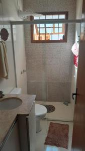 een badkamer met een toilet, een wastafel en een douche bij Casa Ana y Ángelo in Pântano Grande