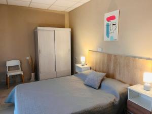 a bedroom with a bed and two lamps and a cabinet at Apart Los Laureles Dpto 2 in Villa Regina