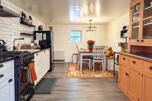 a kitchen with a table and a stove top oven at Peak View Guesthouse - Walk to Garden of the Gods - Hot Tub - Epic Views! in Colorado Springs