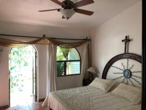 Un dormitorio con una cama y un ventilador de techo. en Quinta Charito, Amplia Villa Familiar junto al Mar, en Los Cocos 45 fotos más