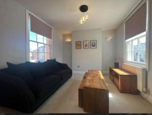 a living room with a black couch and a coffee table at Two bed town house in Royal Leamington Spa in Leamington Spa