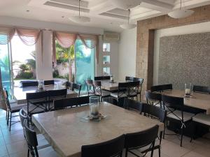 Un comedor con mesas y sillas y una pizarra. en Quinta Charito, Amplia Villa Familiar junto al Mar, en Los Cocos