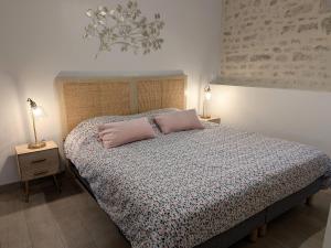 a bedroom with a bed with a pink pillow on it at Charmant gîte à la ferme avec terrasse et vue sur la mare - FR-1-590-540 in Chilleurs-aux-Bois