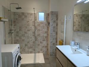 a bathroom with a shower and a sink and a washing machine at Charmant gîte à la ferme avec terrasse et vue sur la mare - FR-1-590-540 in Chilleurs-aux-Bois +10 photos