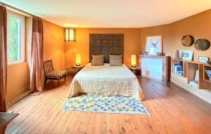 ein Schlafzimmer mit großem Bett und Kamin in der Unterkunft 3 Bedroom Gorgeous Home In Arjuzanx in Arjuzanx