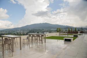 a patio with tables and chairs on a roof at Glam - Apartamento exclusivo cerca del Consulado de México y centros comerciales in Quetzaltenango