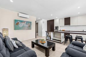 salon z kanapą i stołem oraz kuchnią w obiekcie Paradiso Resort by Kingscliff Accommodation w mieście Kingscliff