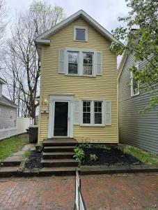 une maison jaune avec un porche et des escaliers dans l'établissement Rise & Shine, à Richmond