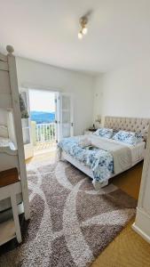 Villa Coração Guesthouse by Concavus في مونتي فيردي: غرفة نوم بسريرين وشرفة