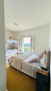 Villa Coração Guesthouse by Concavus في مونتي فيردي: غرفة نوم بسرير كبير مع نافذة كبيرة +27 صورة