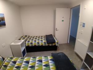 a room with two beds and a door to a hallway at Penny's Drop Inn in Cromwell