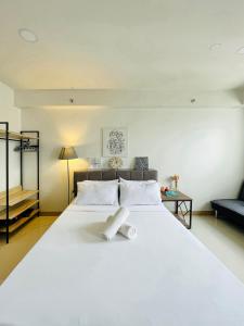 a large white bed with two white towels on it at Elegant Style Studio in SMDC in Cari Mayor
