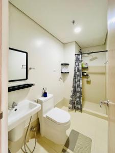 a bathroom with a white toilet and a sink at Elegant Style Studio in SMDC in Cari Mayor