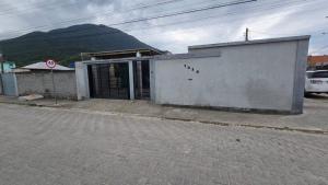 un edificio sul lato di una strada con una montagna di Karina Saraiva a Palhoça