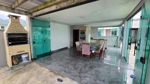 una sala da pranzo con tavolo, sedie e camino di Karina Saraiva a Palhoça