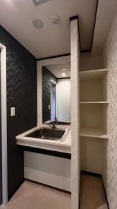 a bathroom with a sink and a mirror at Goddessガッデス in Yokosuka