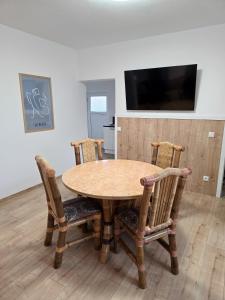 ein Holztisch mit vier Stühlen und ein Fernseher in der Unterkunft Mountain Peak Apartment in Garmisch-Partenkirchen + 25 Fotos
