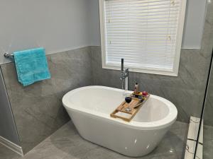 a white bath tub in a bathroom with a window at Luxury 5BR Home with Spa Bath in Burlington