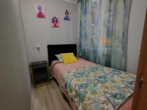 Cette petite chambre comprend un lit avec un oreiller jaune. dans l'établissement DEPTO 3 D 1 B CENTRAL FACTURA Estac, à Chillán