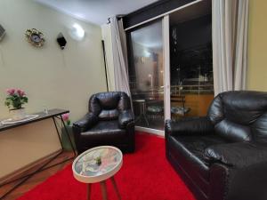 - un salon avec deux fauteuils en cuir et une table dans l'établissement DEPTO 3 D 1 B CENTRAL FACTURA Estac, à Chillán