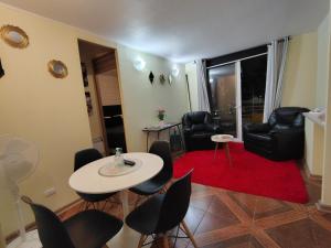 - un salon avec une table, des chaises et un tapis rouge dans l'établissement DEPTO 3 D 1 B CENTRAL FACTURA Estac, à Chillán