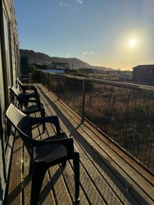 drie banken op een balkon met uitzicht op het water bij Cabañas Mc Chelo Pelluhue in Pelluhue +6 foto's