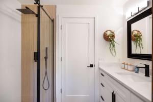 a bathroom with a shower and a sink and a mirror at Bellevue Somerset 2BR w Sunroom & Sweeping Views in Newcastle