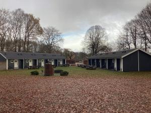 Detached holiday home for four guests في Ansager: مبنى مع ساحة مع مقاعد وطاولات