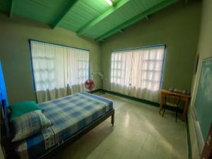 a bedroom with a bed and two windows at Overlooking Budget Hotel in San Pedro Sula