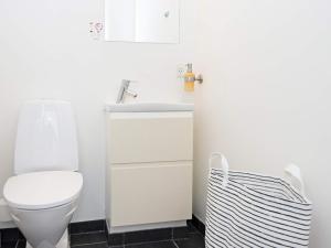a white bathroom with a toilet and a sink at Bright Seaside Apartment in Ebeltoft in Ebeltoft +11 photos