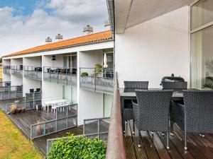 a balcony with chairs and tables on a building at Bright Seaside Apartment in Ebeltoft in Ebeltoft