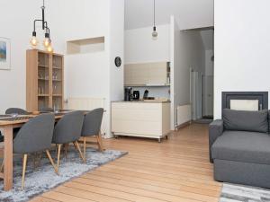 a living room with a table and chairs and a kitchen at Bright Seaside Apartment in Ebeltoft in Ebeltoft