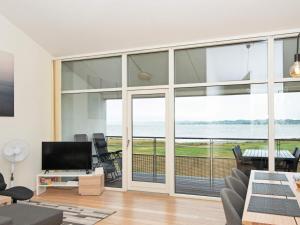 a living room with large glass doors and a view of the ocean at Bright Seaside Apartment in Ebeltoft in Ebeltoft