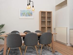 a dining room with a wooden table and chairs at Bright Seaside Apartment in Ebeltoft in Ebeltoft