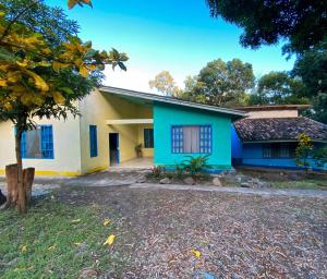 a blue and white house with a tree at Overlooking Budget Hotel in San Pedro Sula