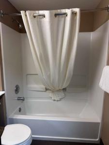 a white bath tub with a shower curtain in a bathroom at Ocean Paradise Hotel & Resort in Ocean Shores