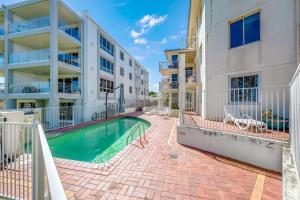 een appartementencomplex met een zwembad naast een gebouw bij Shoreline Apartments - Unit 4b in Bargara