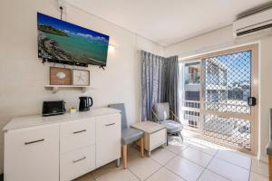 een kamer met een bureau, een stoel en een raam bij Shoreline Apartments - Unit 4b in Bargara