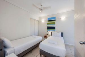 een kleine kamer met 2 bedden en een tafel bij Shoreline Apartments - Unit 4b in Bargara