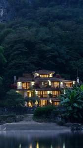 ein großes Gebäude mit Lichtern vor einem Berg in der Unterkunft The Apsara Lodge in Yangshuo