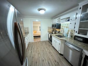 a kitchen with white cabinets and a refrigerator at Old Florida Charm in Eustis