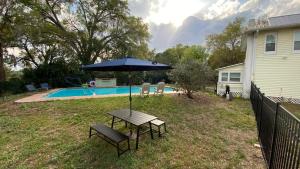 a picnic table with an umbrella next to a pool at Old Florida Charm in Eustis