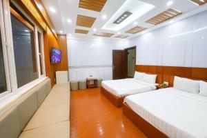 a hotel room with two beds and a tv at Van Ha Hotel Etown - Nhà Ga T3 Sân Bay TSN in Ho Chi Minh City