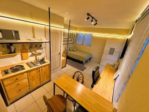 a small kitchen with a table and a room with a bed at Modern Loft #1 in Puerto Barrios