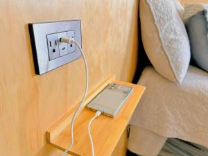 a ipod plugged into an outlet on a table next to a couch at Modern Loft #1 in Puerto Barrios